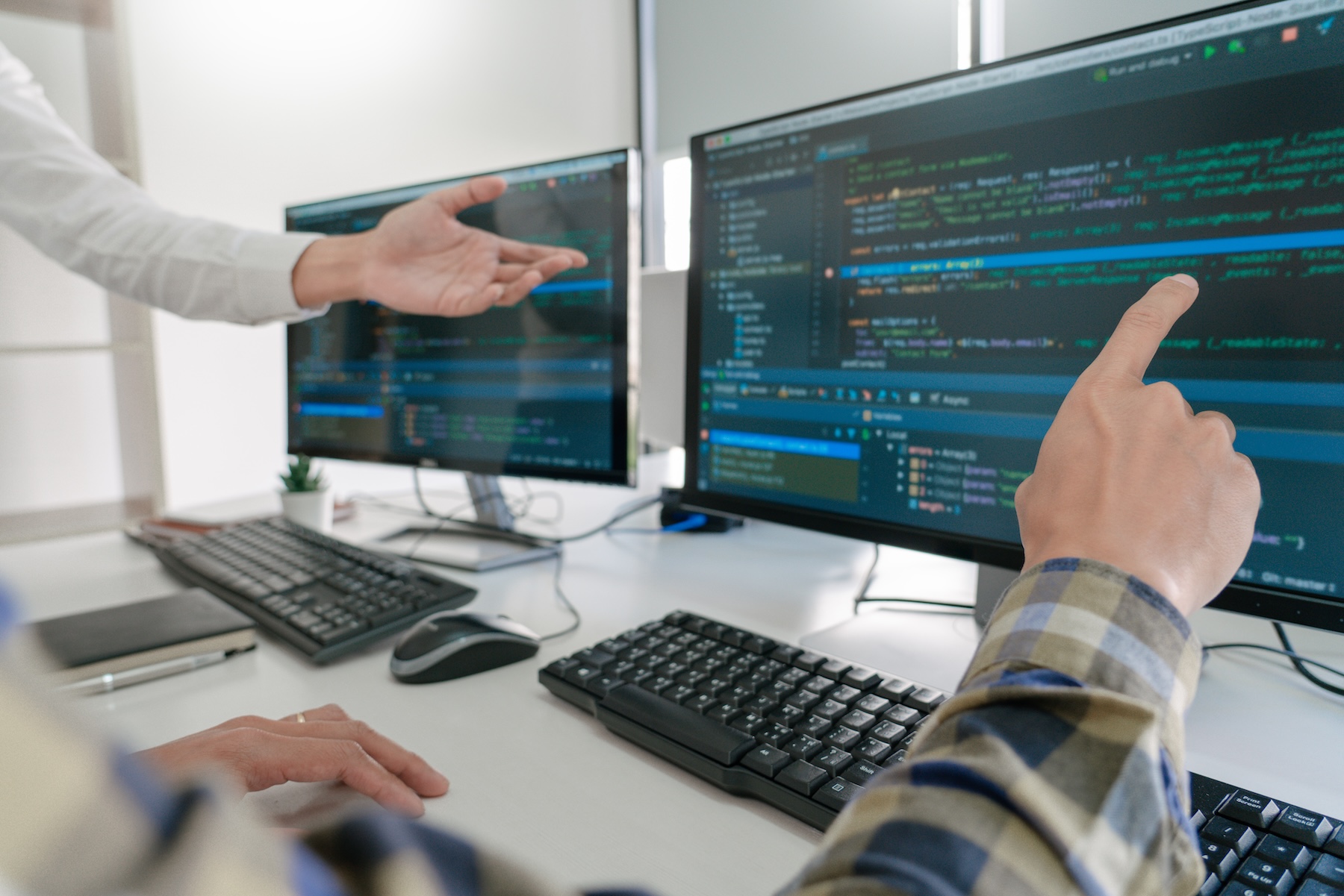 il debito tecnico nel software: programmatori che discutono davanti al codice